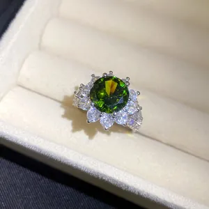 Nahaufnahme eines runden grünen Zirkonia-Rings mit Blumen-Halo-Fassung