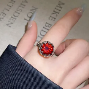 Detailaufnahme eines silbernen Blumenrings mit einem brillanten roten Zirkonia-Stein