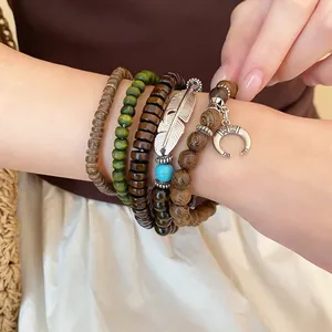 Close-up of Bohemian beaded bracelet set with silver feather and crescent moon charms.