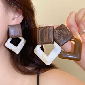 Close-up detail showing the natural wood grain and polished acrylic texture of vintage earrings