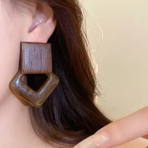 Macro view of vintage Maillard style geometric earring with wood texture and brown acrylic resin