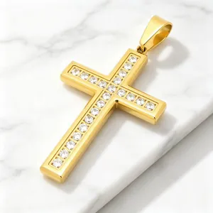 Close-up of a gold-plated titanium steel cross pendant with sparkling rhinestones.