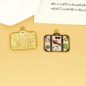 Macro detail of enamel suitcase travel charm with heart patterns and gold metal base
