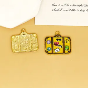 Detail of suitcase-shaped enamel charm with travel-themed prints for DIY jewelry making