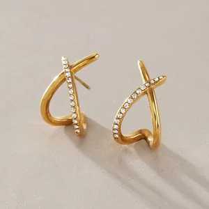 Detail view of gold-plated stainless steel criss-cross earrings with clear rhinestones.