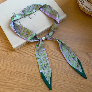Detailansicht des lavendelfarbenen Seidenschals mit Blumenmuster und weißer Perle