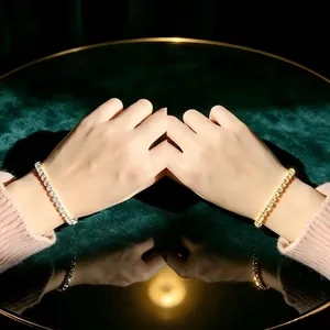 Elegante Gold- und Silber-Tennisarmbänder mit Zirkonia am Handgelenk eines Models