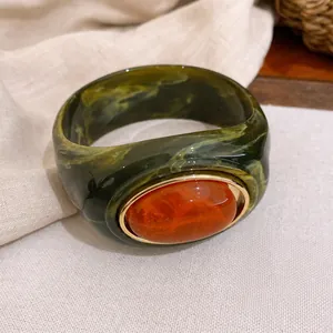 Vintage-Armreif aus grünem marmoriertem Acryl mit großem orangefarbenem Harzstein.