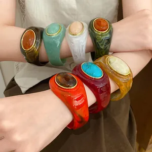 Nahaufnahme bunter Acryl-Armbänder mit Marmormuster an einem Model-Arm