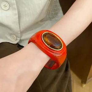 Nahaufnahme eines roten Acryl-Armbands im Vintage-Stil mit einem großen bernsteinfarbenen Stein