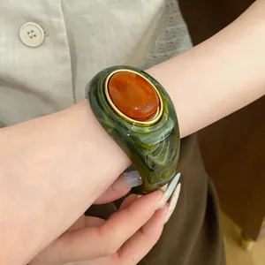 Detailansicht eines Vintage-Acryl-Marmorarmreifs mit großem orangefarbenem Mittelstück
