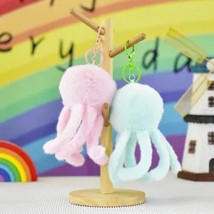 Detailed close-up of pink and blue plush jellyfish keychains on a wooden display stand.