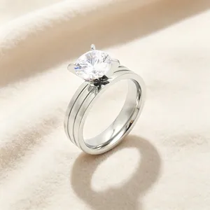 Macro view of four-prong set round cubic zirconia on a triple-line grooved titanium steel ring