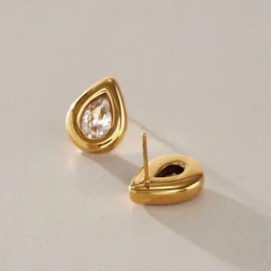 Detailaufnahme eleganter goldener Tropfenohrringe mit funkelndem klarem Zirkonia-Stein