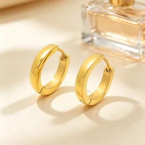 Close-up detail of minimalist gold stainless steel hoop earrings with a polished smooth finish