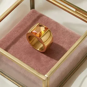Macro view of a gold-plated titanium steel ring with a large amber glass stone
