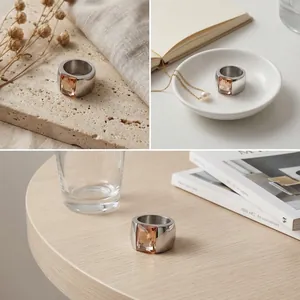 Detailed view of a wide titanium steel ring with an amber glass gemstone in lifestyle settings
