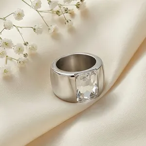 Close-up of a wide titanium steel ring featuring a large rectangular clear glass stone