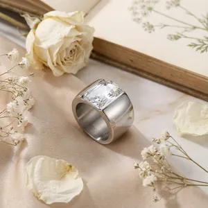 Close-up of titanium steel wide band ring with a large rectangular clear stone