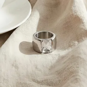 Macro detail of a wide silver titanium steel ring with a large rectangular glass stone