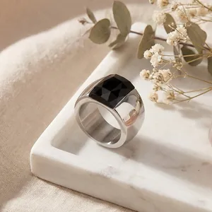 Macro shot showing details of a wide titanium steel ring with a faceted black glass stone