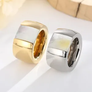 High-quality close-up of gold and silver wide-band titanium steel rings with shell inlay