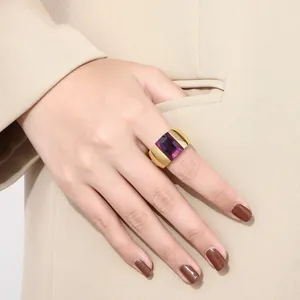 Detail view of a gold-plated titanium steel ring with a large purple rectangular stone.