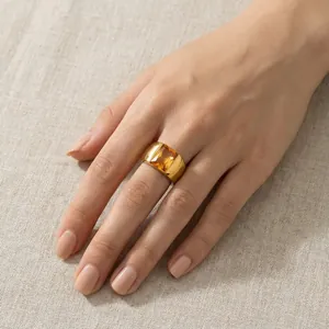 Macro shot of a wide titanium steel ring with a large orange rectangular gemstone.