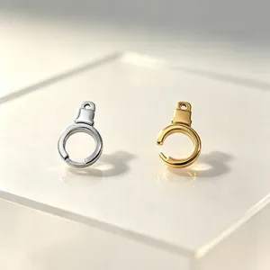 Macro detail of rotatable stainless steel handcuff pendants in gold and silver finishes.