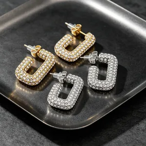 Detailed macro view of gold and silver full-diamond paved U-shaped hoop earrings
