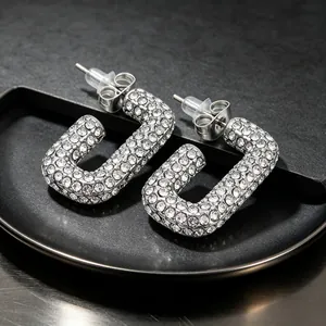 Detailed macro shot of silver-toned stainless steel earrings with full rhinestone pavé.