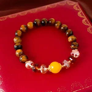 Close-up of a tiger eye stone beaded bracelet featuring vibrant yellow and crystal accents.