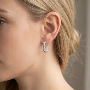 Detailed view of silver oval earrings fully encrusted with shimmering crystals on model