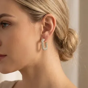Detailed side view of elegant full rhinestone oval stainless steel hoop earring on a model