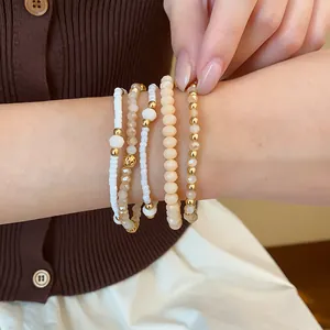 Gros plan détaillé d'un ensemble de bracelets en perles de style bohème en crème et or