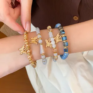 Gros plan d'un ensemble de bracelets bohèmes avec breloques papillon dorées