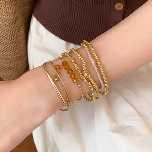 Gros plan d'un ensemble de bracelets bohèmes empilables en perles d'or avec cristaux