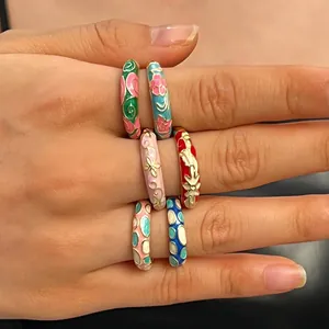 Detail view of colorful cloisonné enamel rings with intricate floral and dot patterns