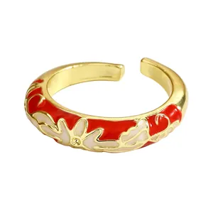 Detail view of red and white enamel floral pattern on gold-finished cloisonné ring