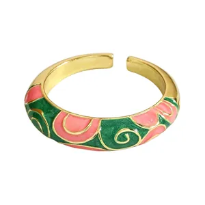 Close-up of a vintage enamel cloisonne open ring with pink and green floral patterns.