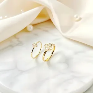 Detailed view of gold titanium steel four-leaf clover rings with sparkling crystals