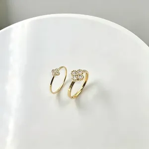 Detail view of golden titanium steel four-leaf clover rings with sparkling rhinestones.