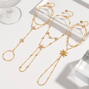 Detailansicht von drei goldenen Edelstahl-Handketten mit Blumen-, Stern- und Sonnenmotiven