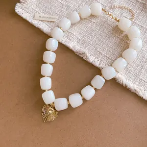 Elegant retro resin geometric beaded necklace featuring a golden heart sunburst pendant