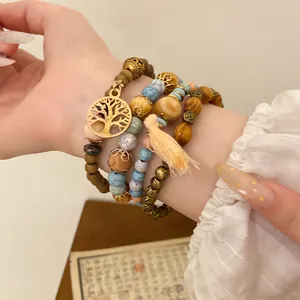 Detailansicht böhmischer stapelbarer Armbänder mit einem goldenen Lebensbaumanhänger