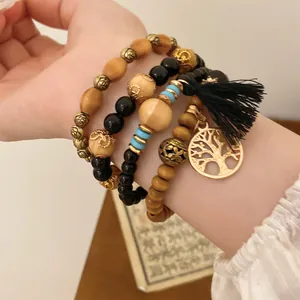 Nahaufnahme eines 4-teiligen Boho-Armband-Sets mit Holzperlen und Baum des Lebens.