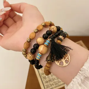 Detailansicht des 4-teiligen Boho-Armbandsets mit Holzperlen und Lebensbaum-Anhänger