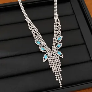 Gros plan détaillé d'un collier à pompons argenté orné de pierres de zircon bleu clair