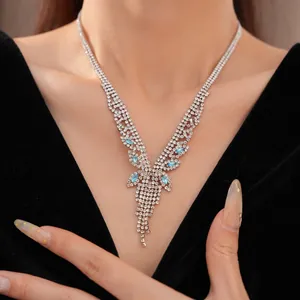Gros plan d'un collier vintage à pompons avec des cristaux de zircone clairs et bleus.