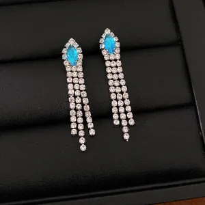 Détail de boucles d'oreilles à pampilles plaquées or 14 carats avec zircon bleu marquise